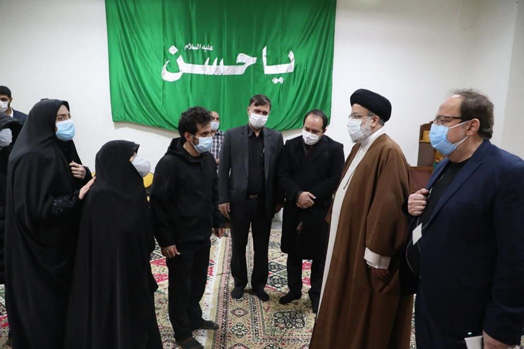Iran's Judiciary Chief Ayatollah Ebrahim Raisi (2nd-R) pays respects to the body of slain scientist Mohsen Fakhrizadeh among his family, in the capital Tehran on November 28, 2020.