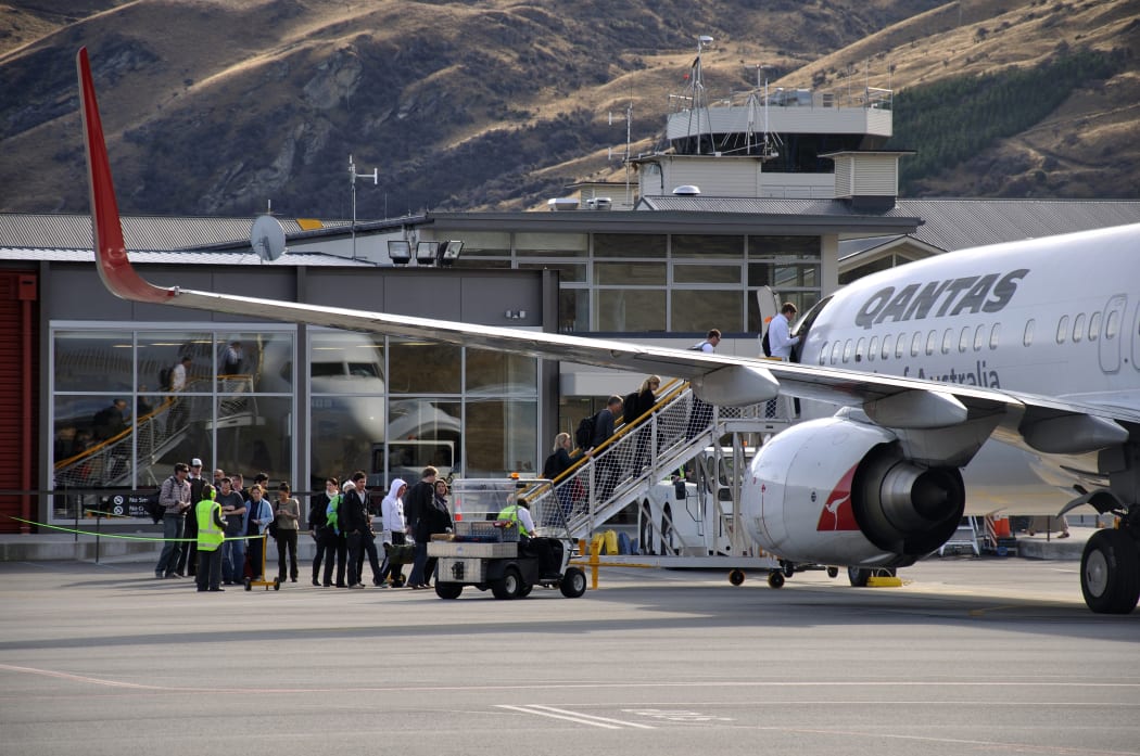 Passengers board commercial jet at Queenstown Airport.