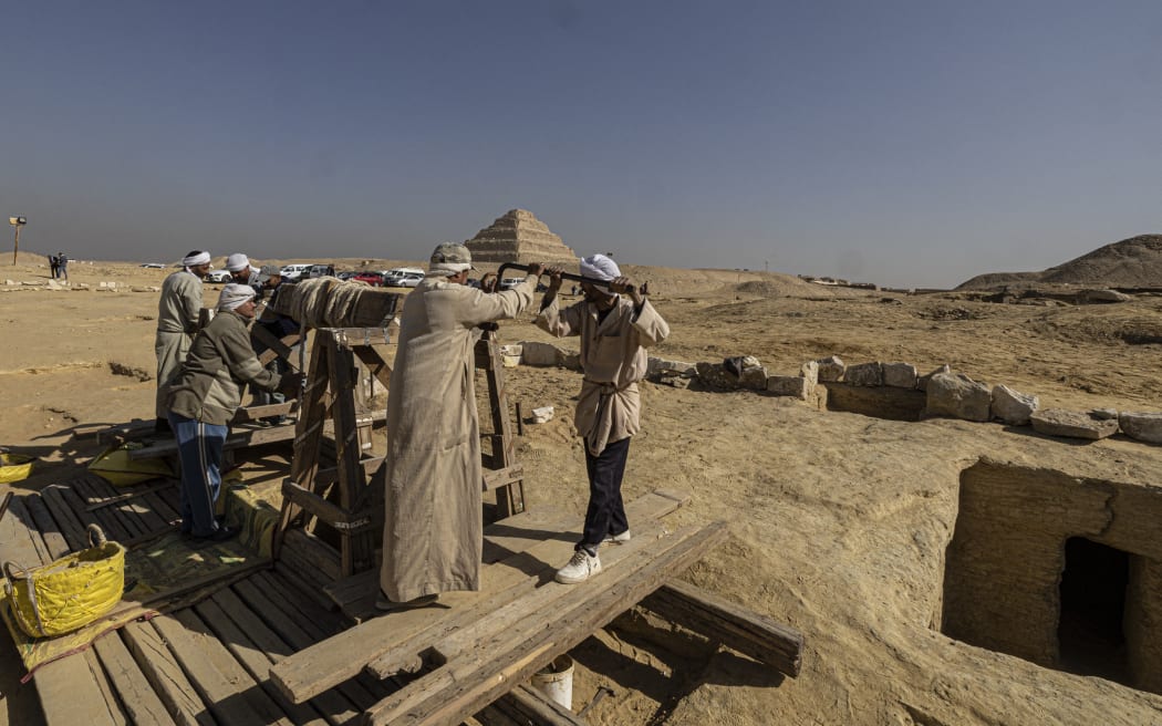 Egyptian antiquities workers at the Saqqara archaeological site on 26 January, 2023, where a gold-laced mummy and four tombs including of an ancient king's 
