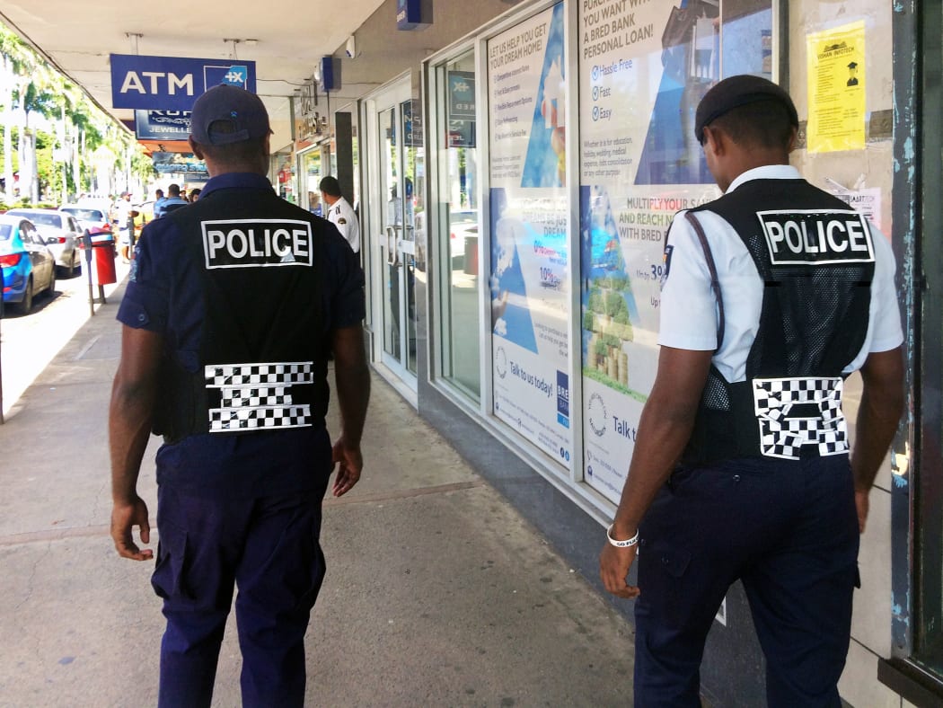 70710201 - lautoka, fiji -  dec 30 2016:fijian police officers patrolling in the main street. the fiji police force annual statistics reveal an 18% increase in crime cases in 2015.