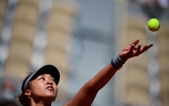 Foto de archivo: la japonesa Naomi Osaka mira la pelota mientras sirve a la rumana Patricia Maria Tig durante el partido de tenis de la primera ronda de individuales femeninos en el primer día del torneo de tenis del Abierto de Francia.