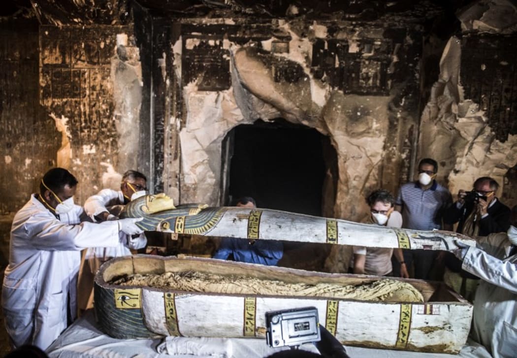 Egypt's Antiquities Minister Khaled el-Enany (2nd-R) and Mostafa Waziri (C, behind), the Secretary General of the Supreme Council of Antiquities, inspect an intact sarcophagus during its opening at the site of Tomb TT33 in the southern Egyptian city of Luxor.