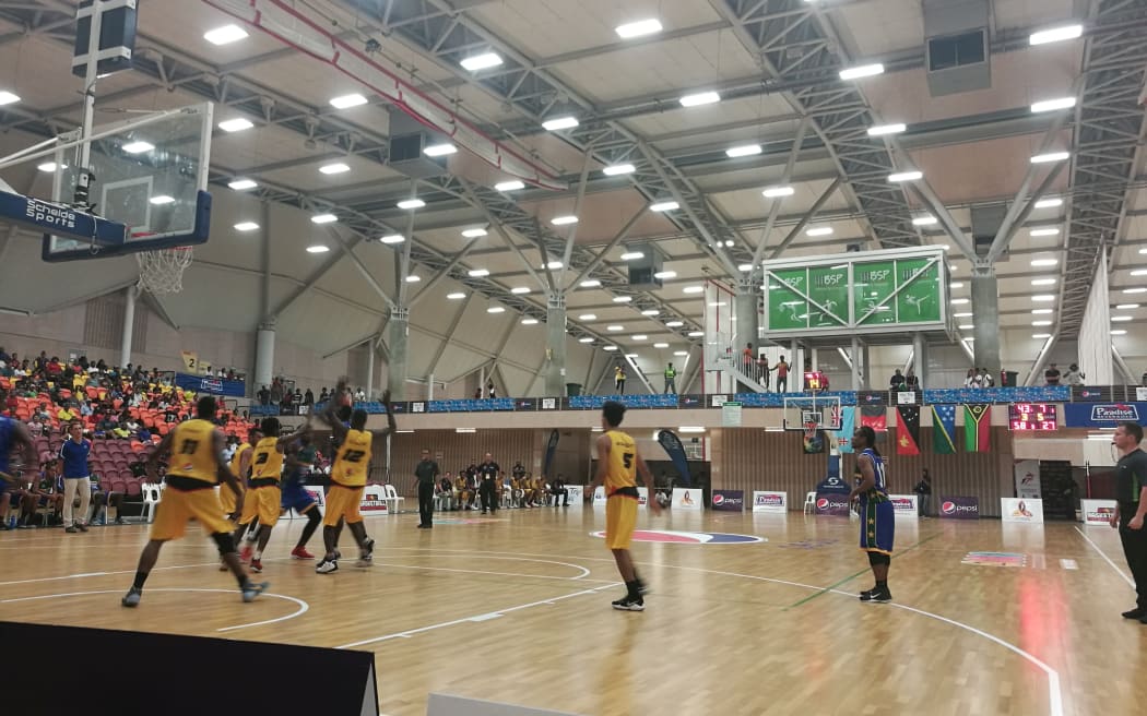 The PNG men, in yellow, taking on Solomon Islands during the Melanesian Basketball Cup in Port Moresby.