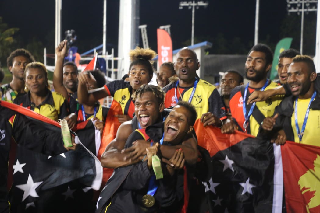 Toea Wisil (c) and Team PNG celebrate their medal haul on the track.