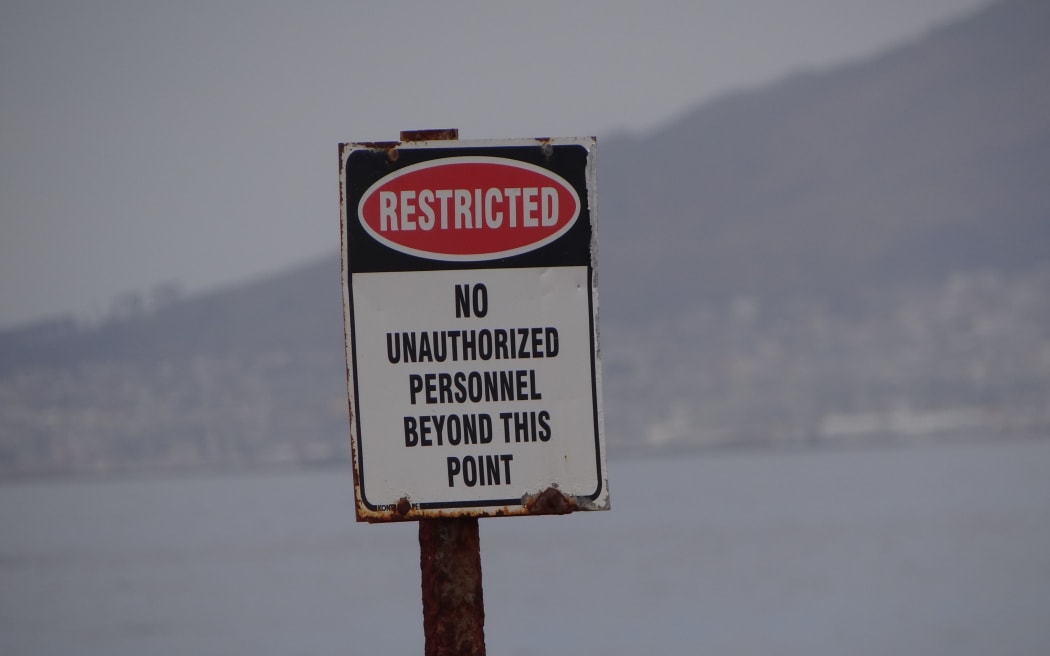 A sign that reads 'Restricted. No unauthorised personnel beyond this point'.
