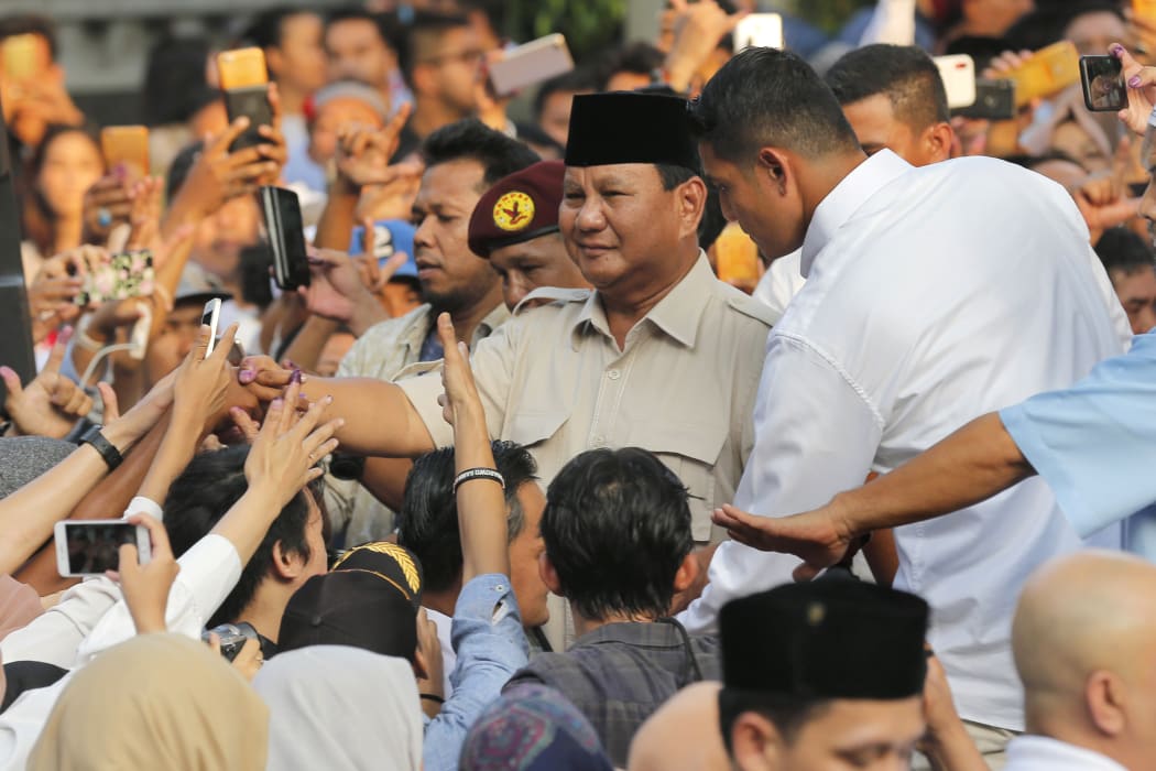 Indonesian presidential candidate Prabowo Subianto, center, shakes hands with his supporter after press conference in Jakarta, Indonesia on 17 April, 2019.