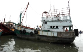 A wooden fishing boat used to transport nearly 600 mostly Rohingya migrants rests anchored at Lhokseumawe in Indonesia on 14 May.