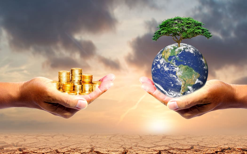 The left hand holds money. Right hand holding a earth There is a bokeh background. Design concept Nature or capitalism. element of the picture is decorated by NASA