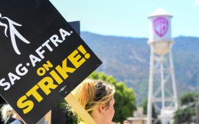 Members of the Writers Guild of America and the Screen Actors Guild walk a picket line outside of Warner Bros Studio in Burbank, California, on July 26, 2023. Tens of thousands of Hollywood actors went on strike at midnight July 14, 2023, effectively bringing the giant movie and television business to a halt as they join writers in the first industry-wide walkout for 63 years. (Photo by VALERIE MACON / AFP)