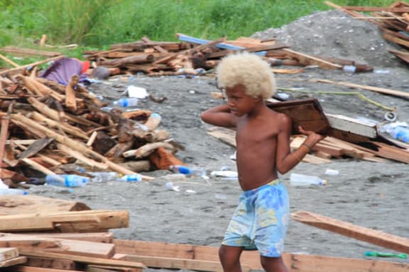 A boy among the rubble left by flooding in the Solomon Islands.