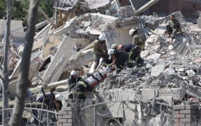 Rescuers carry a body from a destroyed building hit by a missile strike on 1 July in the Ukrainian town of Sergiyvka , near Odesa, killing and injuring many people.