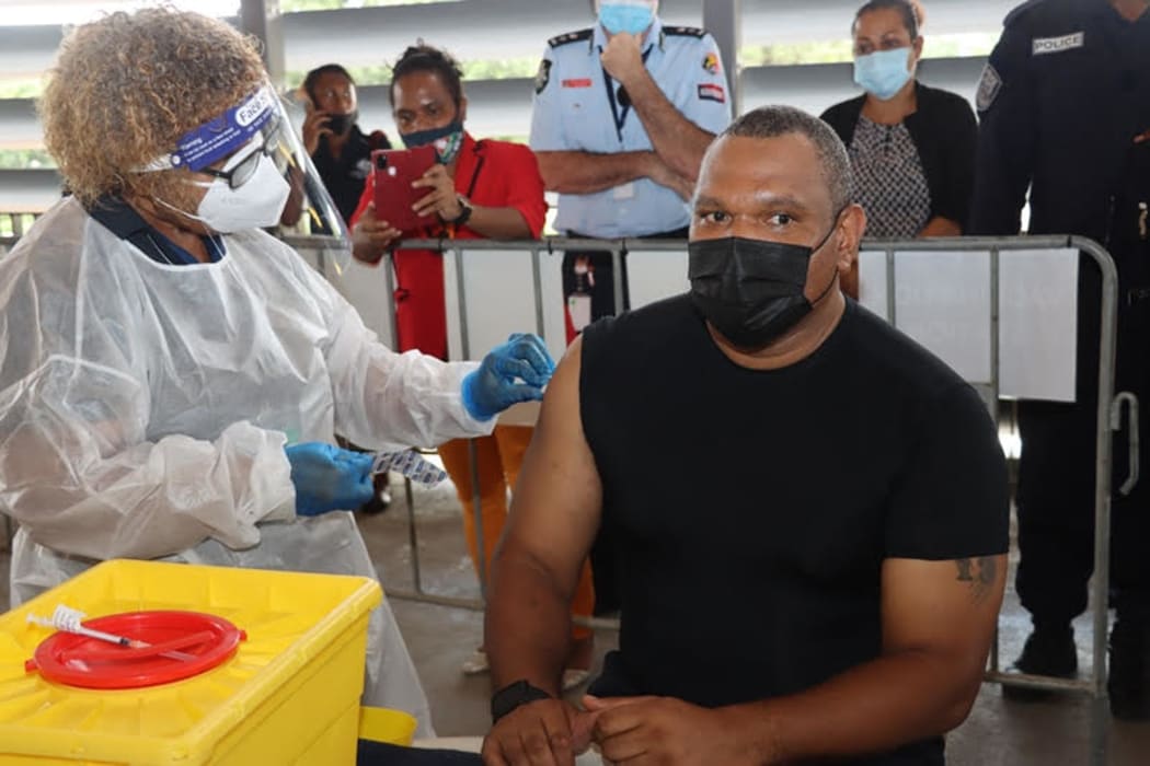 The Controller of the PNG National Pandemic Response, David Manning, receives a shot of the Covid-19 vaccine produced by Astrazeneca.
