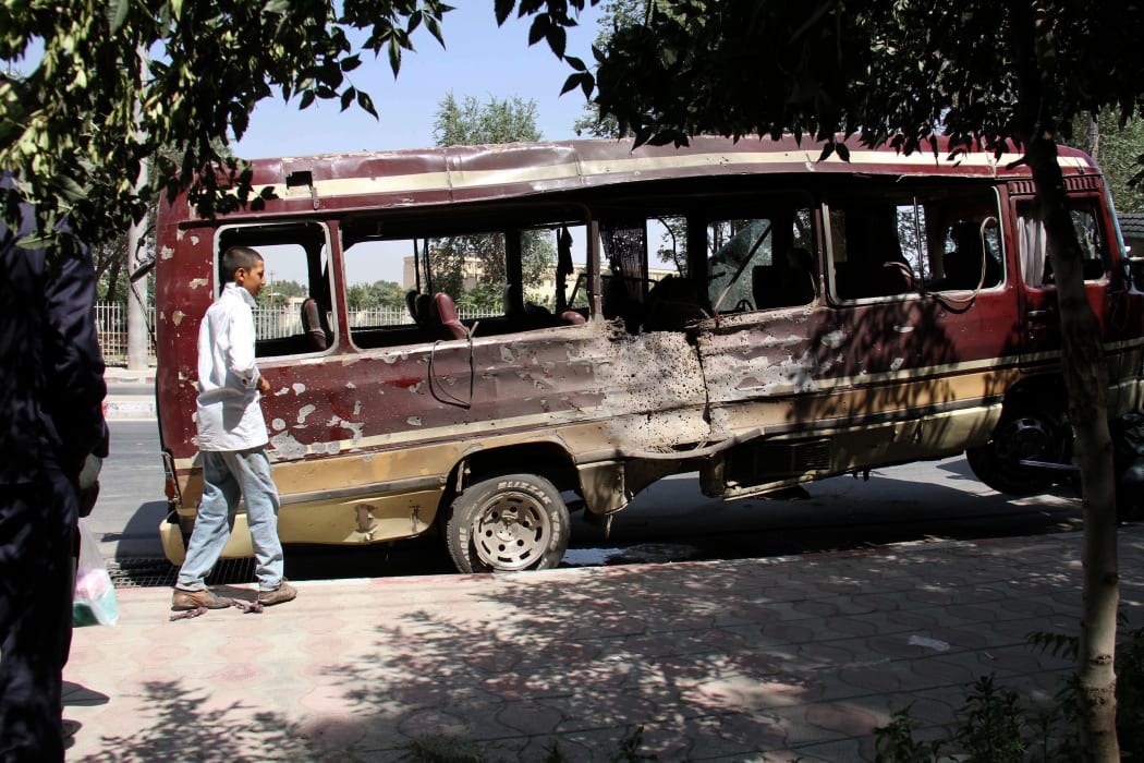 A boy walks past the wreckage of a bus following a suicide bombing in Kabul.