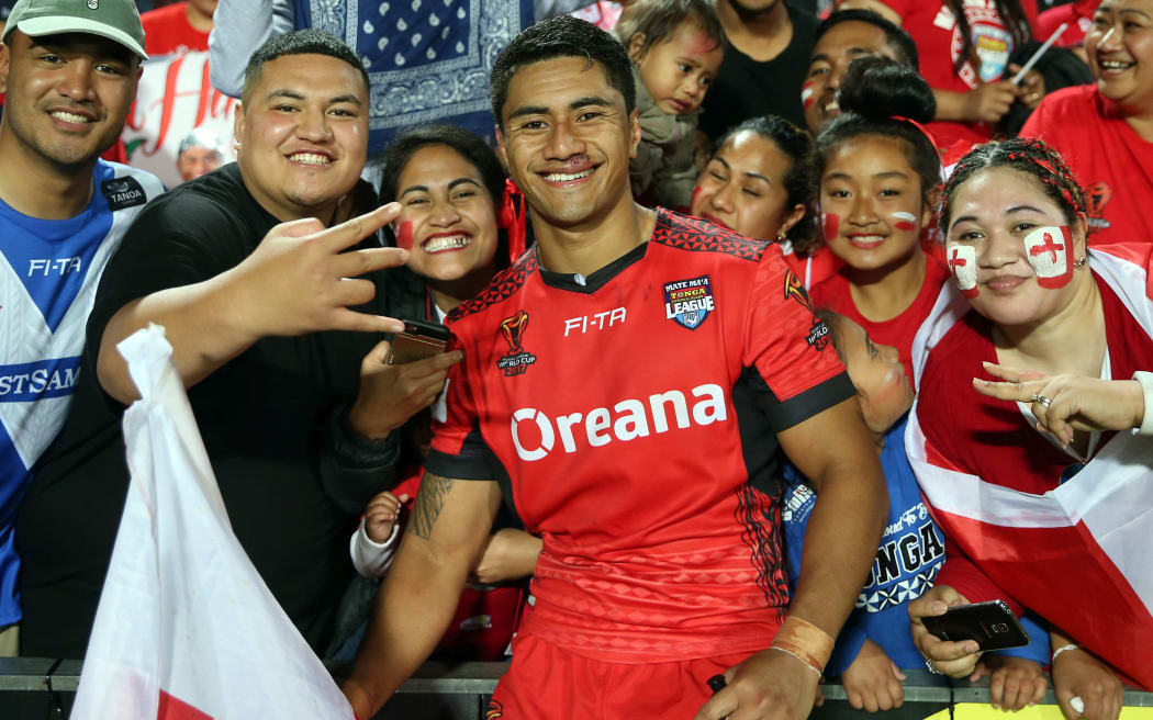 Tongan scrumhalf, Ata Hingano, poses with fans after playing a pivotal part in victory over Samoa