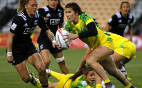 Australia's Charlotte Caslick breaks New Zealand's defence.