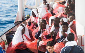 Migrants are rescued from a boat off the Libyan coast in December 2016. About 100 people are now missing after the boat they were on sank.