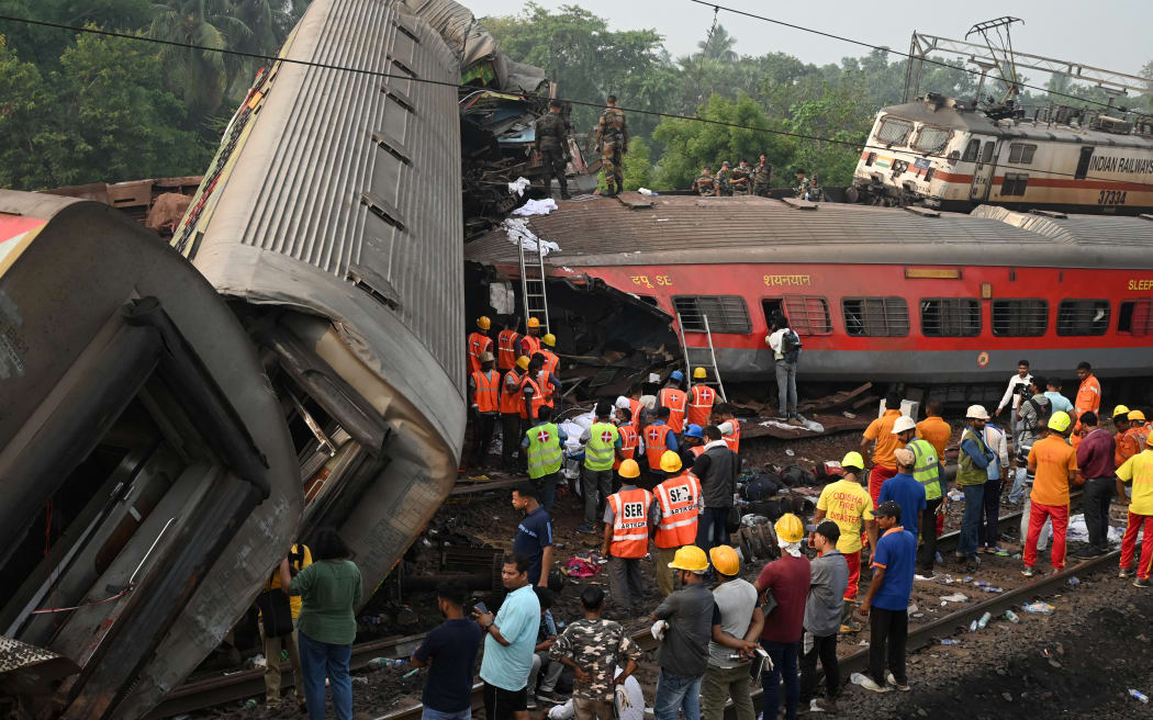 Ratownicy gromadzą się wokół zniszczonych wagonów w miejscu zderzenia trzech pociągów w pobliżu Balasore, około 200 kilometrów (125 mil) od stolicy stanu Bhubaneswar we wschodnim stanie Odisha, 3 czerwca 2023 r. Zginęło co najmniej 288 osób.  Ponad 850 rannych w straszliwym zderzeniu pociągu w Indiach, poinformowali urzędnicy 3 czerwca, najbardziej śmiertelny wypadek kolejowy w kraju od ponad 20 lat.  (Zdjęcie: Dibiangsho Sarkar/AFP)
