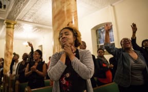 NEW YORK, JUNE 18: Mourners hold a prayer vigil for the victims of the shooting at First African Methodist Episcopal Church: Bethel, in the Harlem neighborhood of New York. The shooting took place at the Emanuel African Methodist Episcopal Church in Charleston, South Carolina.