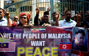 Malaysian activists show the peace sign outside the North Korean Embassy in Kuala Lumpur on Friday during a gathering urging Malaysia and North Korea to come up with a peaceful solution to the current diplomatic row.