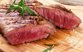 50344317 - grilled beef steak with rosemary, salt and pepper on cutting board