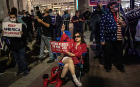 Supporters of US President Donald Trump hold signs and chant slogans during a protest outside the Philadelphia Convention center as votes continue to be counted following the 2020 US presidential election.