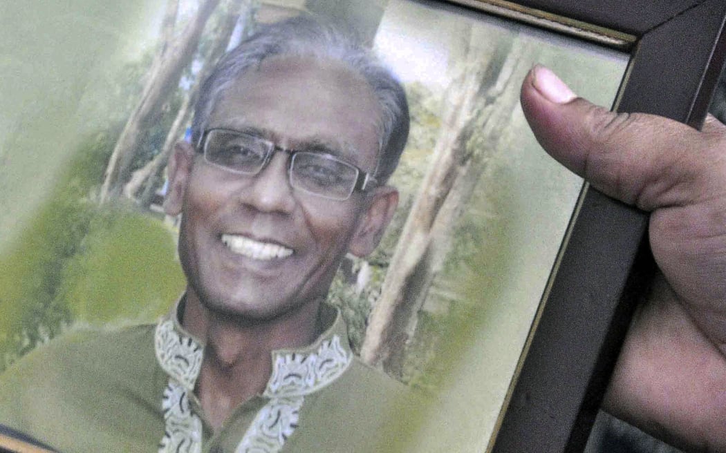 A man holds a portrait of Bangladeshi professor Rezaul Karim Siddique, who was hacked to death by unidentified attackers, in Rajshahi.