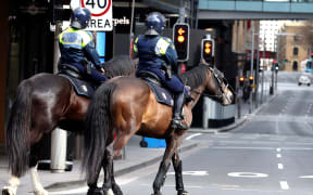 Police on horses patrol the central business district of Sydney on Saturday, as authorities warned against the anti-lockdown protest.
