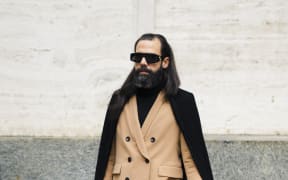 A guest is seen wearing beige suit, cape with fringes outside M1992 during Milan Menswear Fashion Week Autumn/Winter 2019/20 on January 12, 2019 in Milan, Italy. (Photo by Nataliya Petrova/NurPhoto) (Photo by Nataliya Petrova / NurPhoto / NurPhoto via AFP)