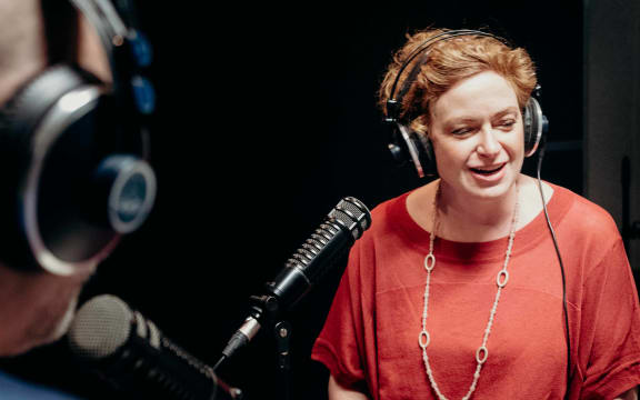 RNZ Morning Report host and journalist Susie Ferguson wearing headphones and looking off to the right as she is interviewed by Reverend Frank Ritchie for the podcast re_covering