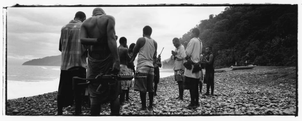Harold Keke (centre, praying) and his GLF guerillas pray on a beach before patrolling, along the Weathercoast, Guadalcanal, Solomon Islands,
2003