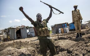 A soldier of the Sudan People Liberation Army celebrates while standing in a trench in Lelo, outside Malakal, in South Sudan.