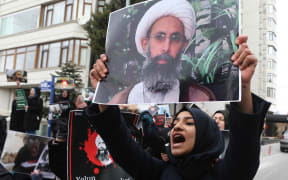 Demonstrators hold pictures of Shiite cleric Sheikh Nimr al-Nimr as they protest outside the Saudi Embassy in Ankara to protest against the execution by Saudi Arabia of the prominent Shiite cleric.
