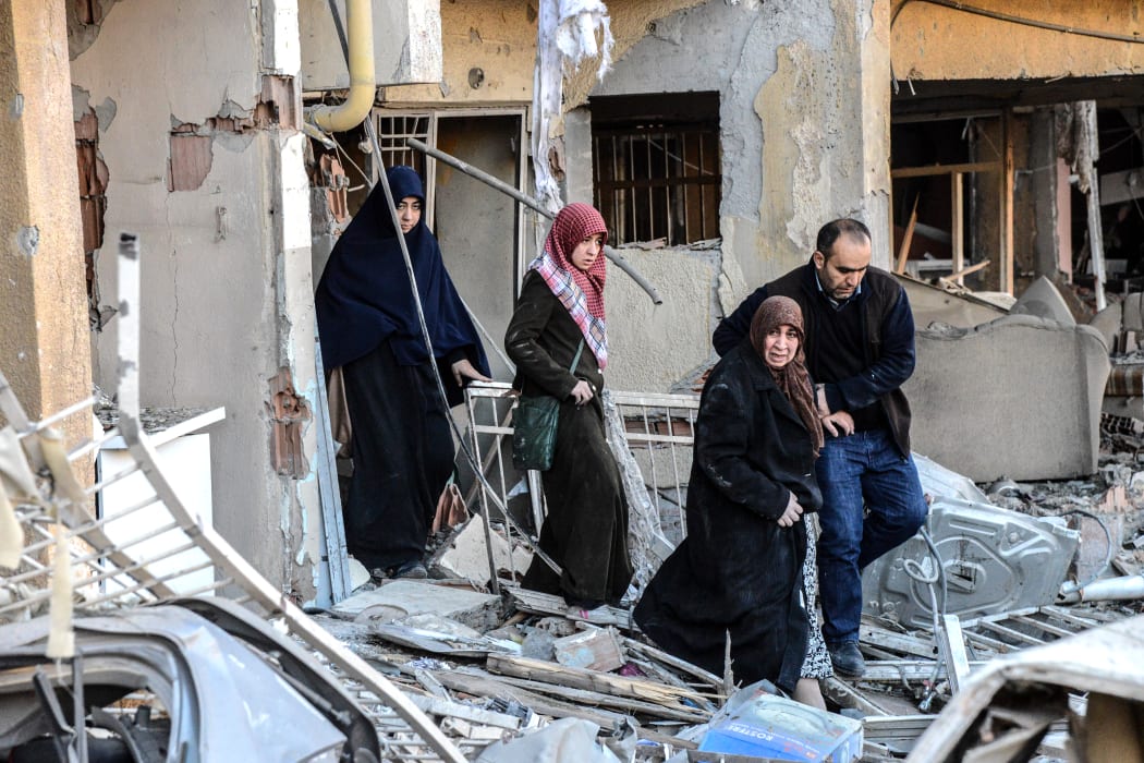 A man and women leave a damaged building at the site of an explosion on 4 November 2016 after a strong blast in Diyarbakir.