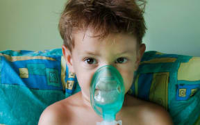 A child with asthma using a nebuliser inhaler for breathing problems (file photo).