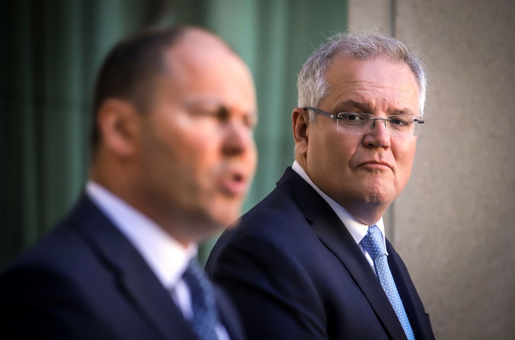 Australian Prime Minister Scott Morrison (R) reacts as he stands with the Australian Treasurer Josh Frydenberg
