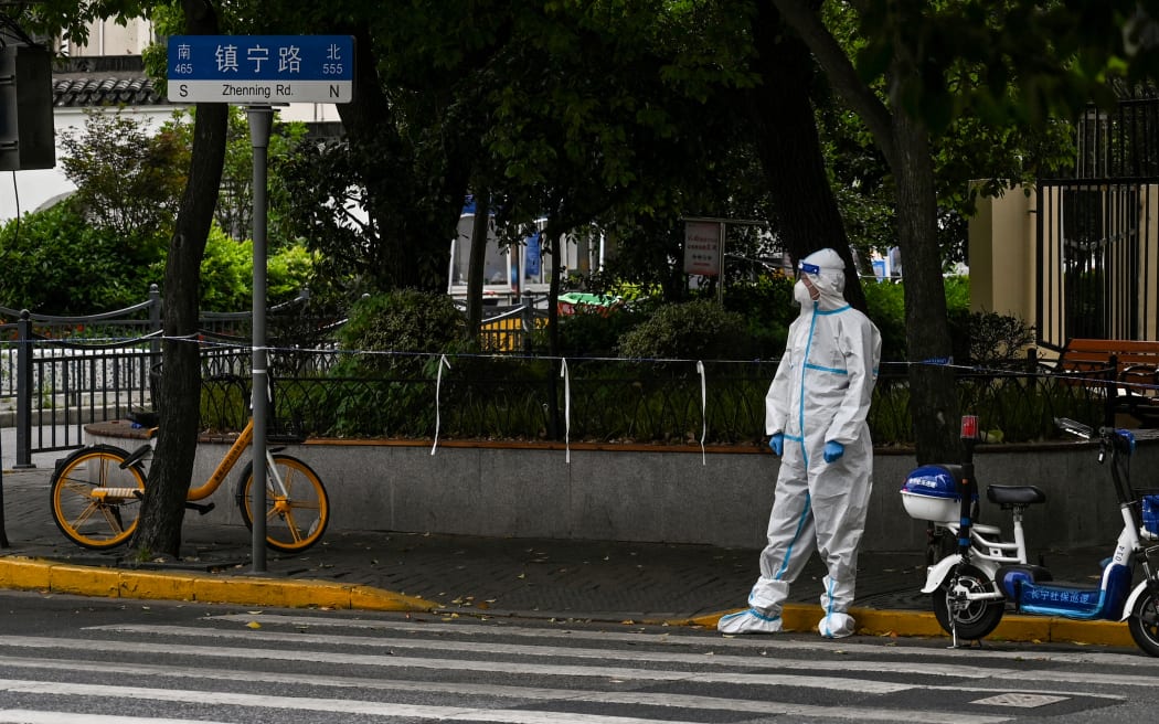 This photo taken on May 10, 2022 shows a worker standing on a street during a Covid-19 coronavirus lockdown in the Jing'an district in Shanghai.