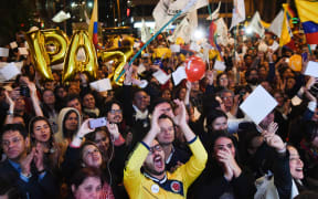 Colombians celebrate as they watch on a giant screen broadcasted from Havana, Cuba, the signing of agreement of conclusion of the peace talks between the Colombian Government and FARC guerrilla,