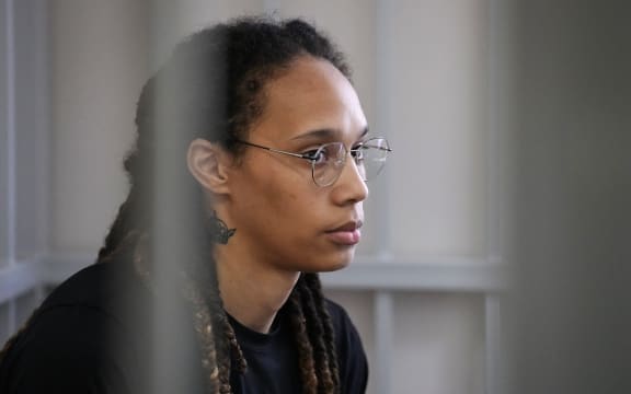 US WNBA basketball superstar Brittney Griner sits inside a defendants' cage before a hearing at the Khimki Court, outside Moscow on July 27, 2022. - Griner, a two-time Olympic gold medallist and WNBA champion, was detained at Moscow airport in February on charges of carrying in her luggage vape cartridges with cannabis oil, which could carry a 10-year prison sentence. (Photo by Alexander Zemlianichenko / POOL / AFP)