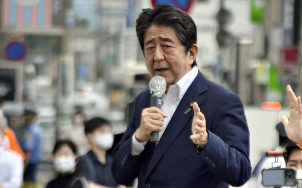 Japanese former Shinzo Abe speaks for his party member candidate of the House of Councillors Election near Yamato Saidaiji Station in Nara Prefecture on July 8, 2022, just seconds before he is shot.