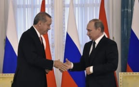 Recep Tayyip Erdoganshakes hands with Vladimir Putin during their press conference in Konstantinovsky Palace.