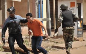 Malian security forces evacuate a man from an area surrounding the Radisson Blu hotel in Bamako