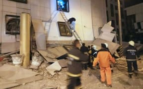 Rescue workers search through rubble outside the Marshal Hotel in Hua-lien