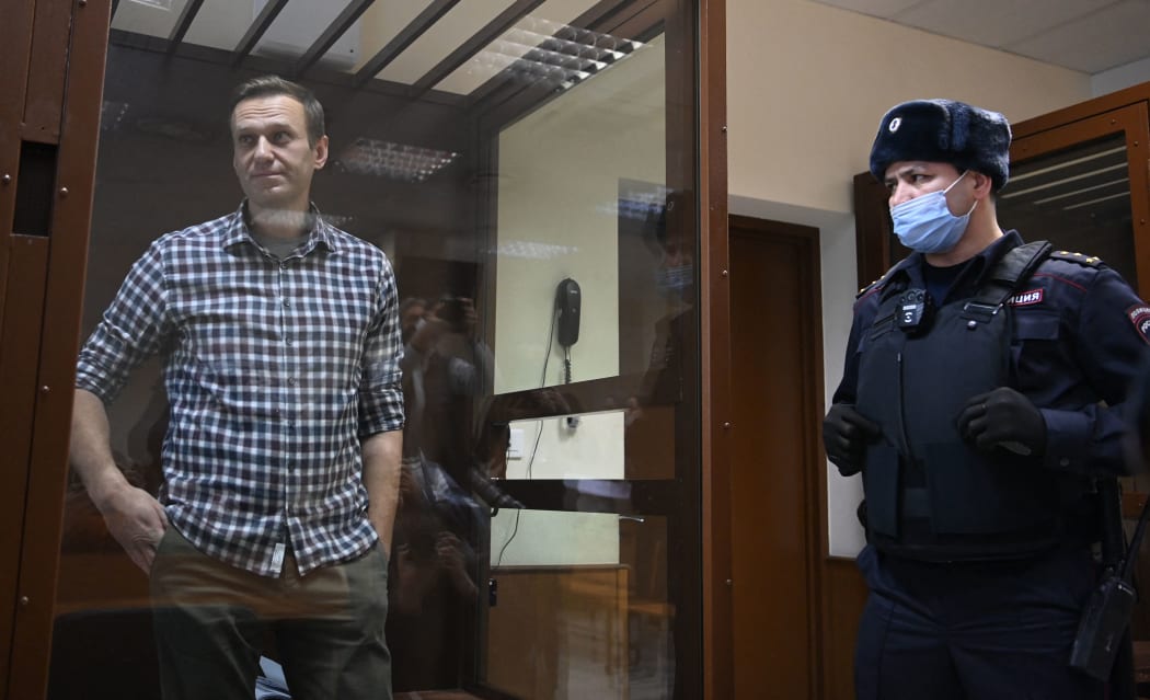Russian opposition leader Alexei Navalny stands inside a glass cell during a court hearing at the Babushkinsky district court in Moscow on February 20, 2021.