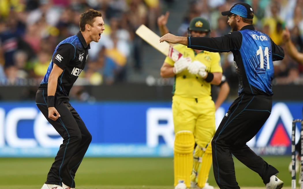 Trent Boult (L) is congratulated by teammate Daniel Vettori (R) after dismissing Australia's Aaron Finch.