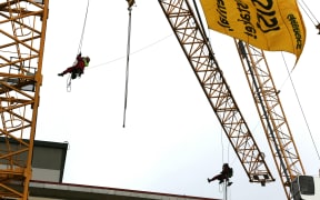Greenpeace protesters unfurl a sign.