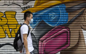 A man wearing a face mask as a precautionary measure against Covid-19 walks on a street in Hong Kong.