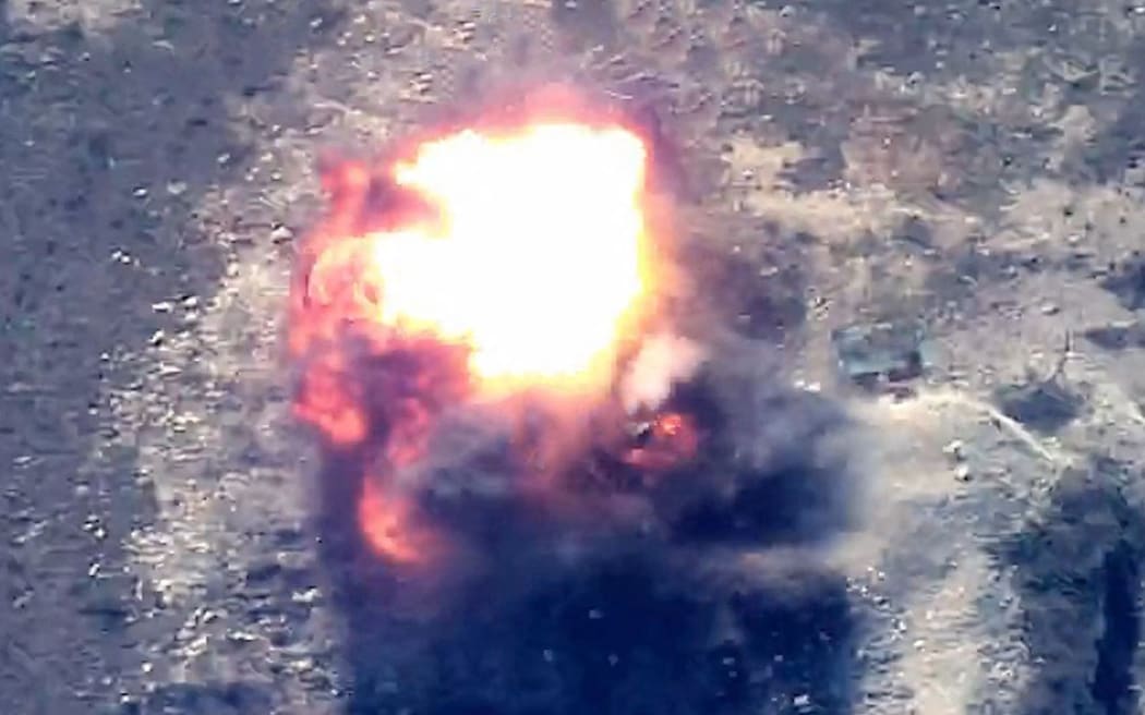This grab taken from handout footage released by the Azerbaijani Defence Ministry on September 19, 2023 shows an explosion in mountainous terrain, that Baku claims to be Azerbaijani forces 