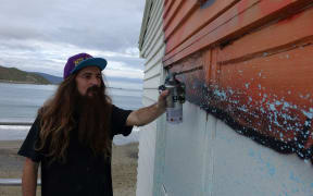 Street artist DSIDE goes to work on the Lyall Bay Surf and Life Saving Club.