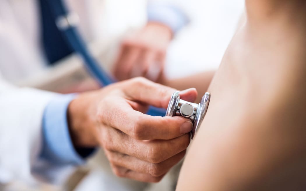 Doctor using stethoscope in examining a small boy