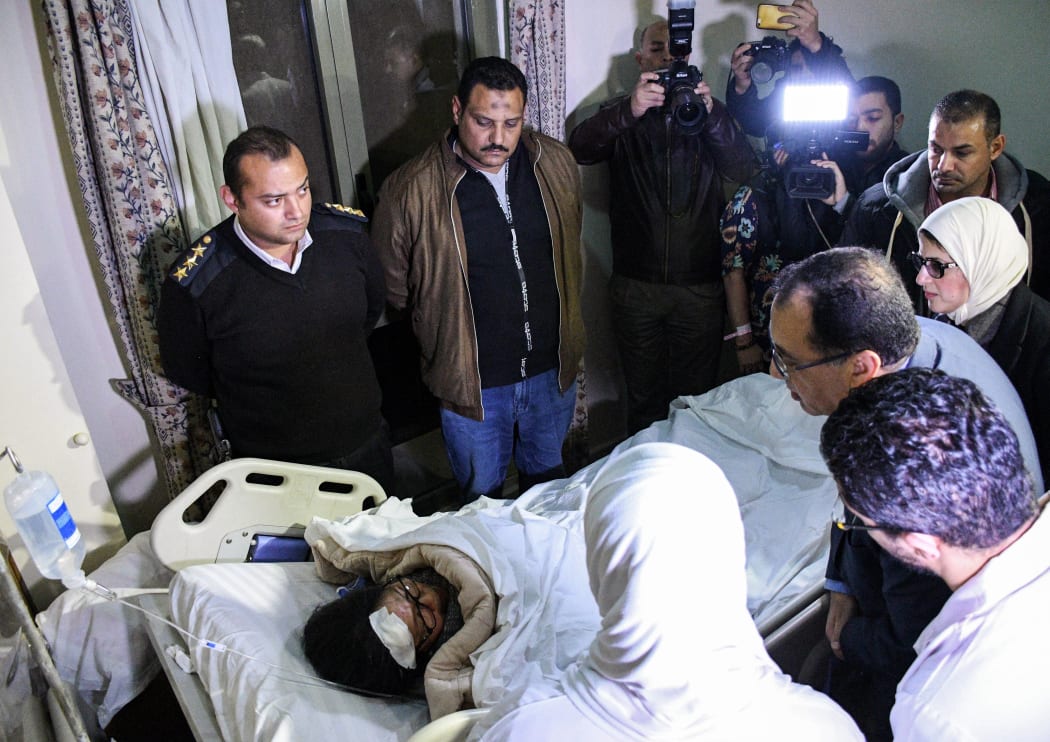 Egypt's Prime Minister Mostafa Madbouli (2nd-R) and Health Minister Hala Zayed (R) visit one of the victims of an attack on a tourist bus that was travelling close to the pyramids the night before, at a hospital in Al-Haram district in the Egyptian capital Cairo's western twin city of Giza.
